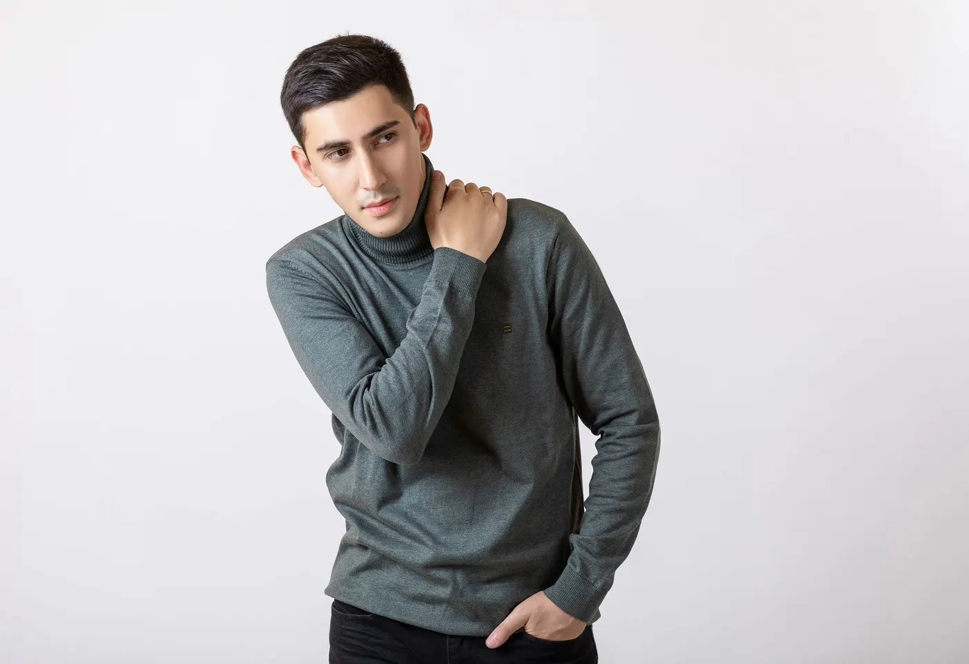 Grey turtleneck against a plain studio background